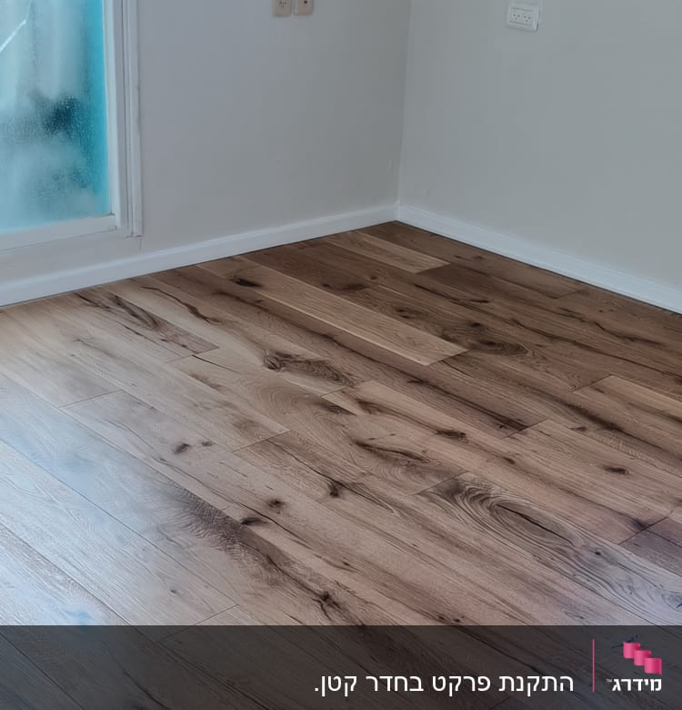 רצפת פרקט עץ בחדר עם קיר לבן